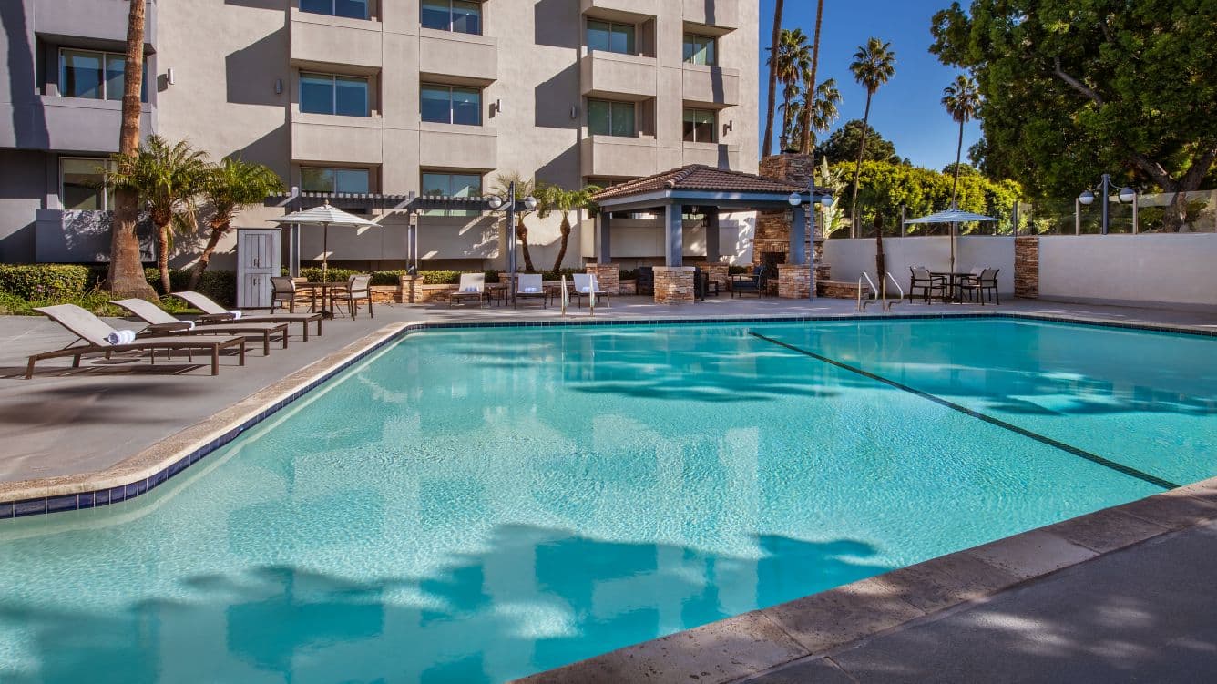 Outdoor heated pool with lounge chairs